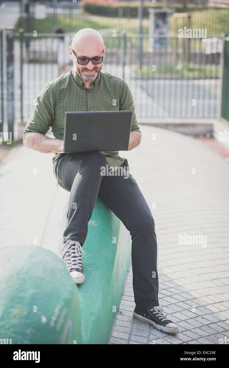 handsome middle aged man using notebook in the city Stock Photo