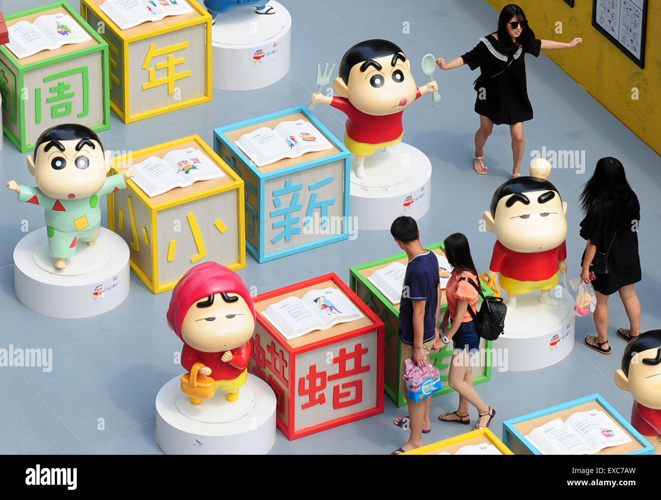 Shenyang. 11th July, 2015. Citizens visit an exhibition marking the 25th anniversary of Japanese manga series Crayon Shin-chan in Shenyang, northeast China's Liaoning Province July 11, 2015. Dozens of manga and theatrical version of Crayon Shin-chan and related figures were displayed on the exhibition that opened to public on Saturday. © Xinhua/Alamy Live News Stock Photo