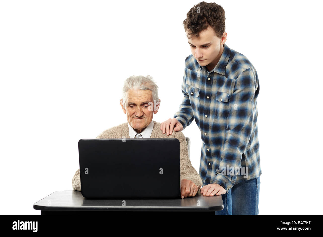 Teenager boy teaching his grandpa how to use a computer Stock Photo