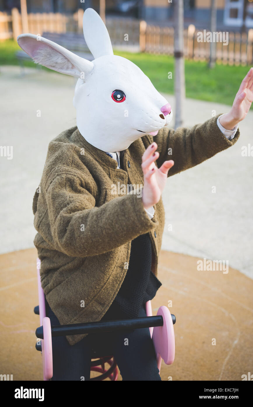 young beautiful asian hipster woman in the city - wearing rabbit mask ...
