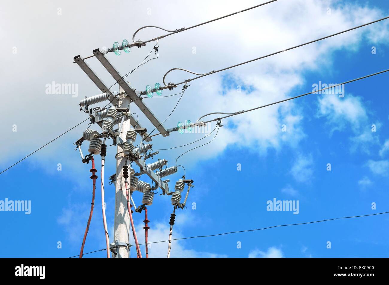 Electric pole in front of a clouded blue sky Stock Photo - Alamy