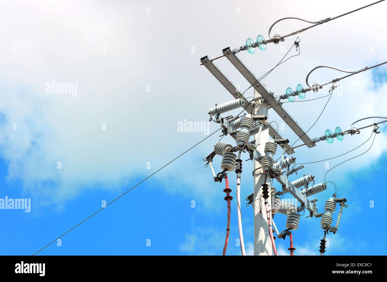 Electric pole in front of a clouded blue sky Stock Photo - Alamy
