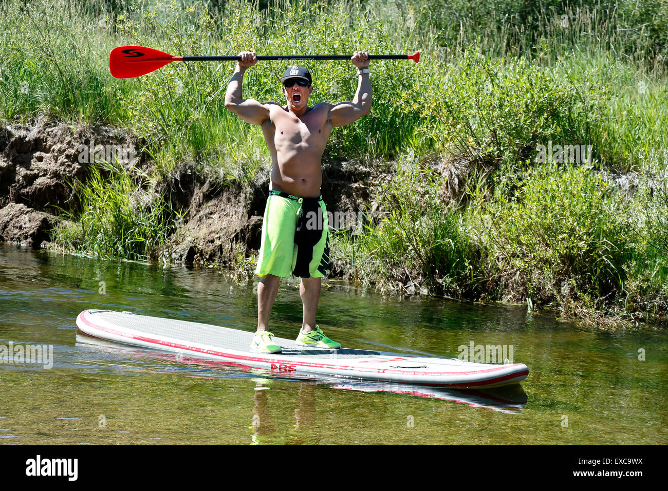 Stand up paddle boarding man, Roaring Fork River, near Aspen, Colorado USA Stock Photo