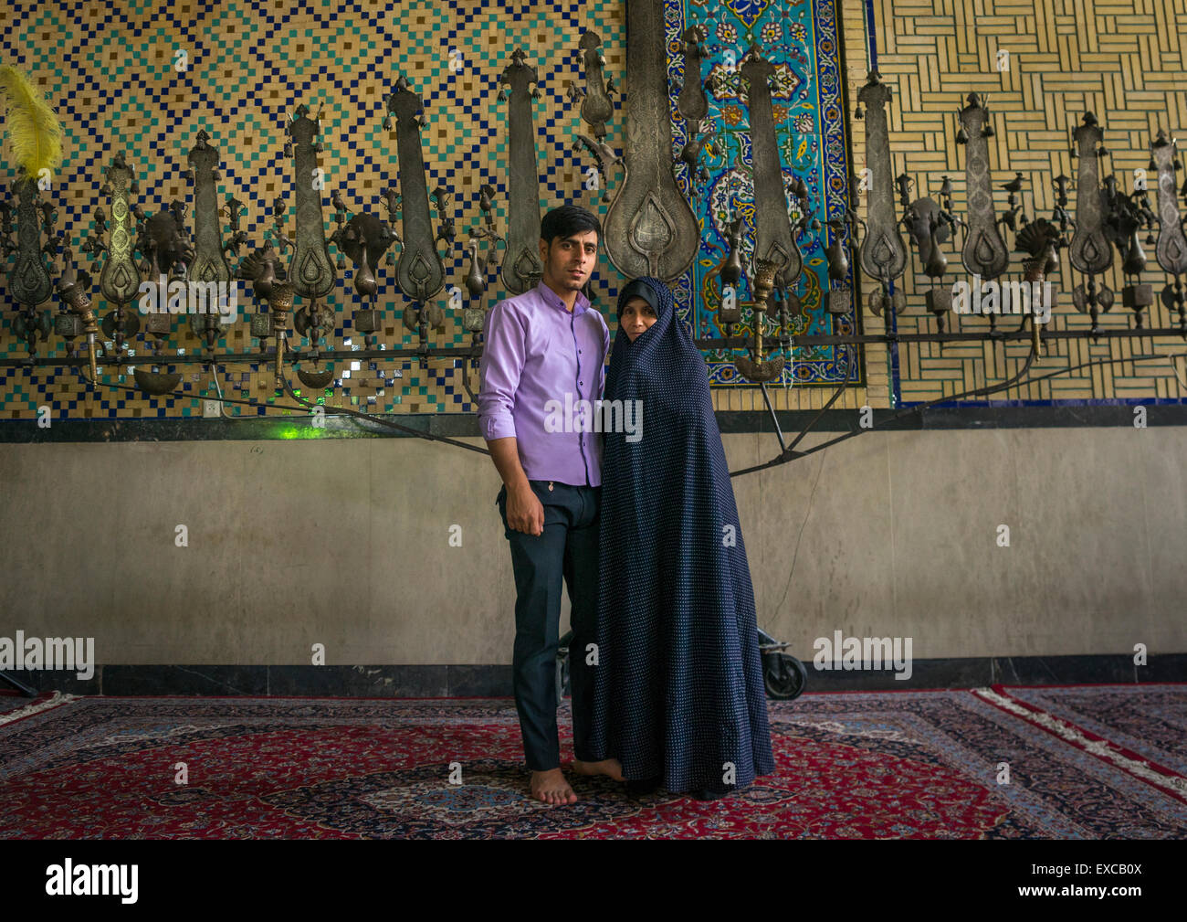 Mother And Son Inside The Shrine Of Hasan Ibn Musa Ibn Ibn Jafar In Front Of An Alam, Isfahan Province, Kashan, Iran Stock Photo
