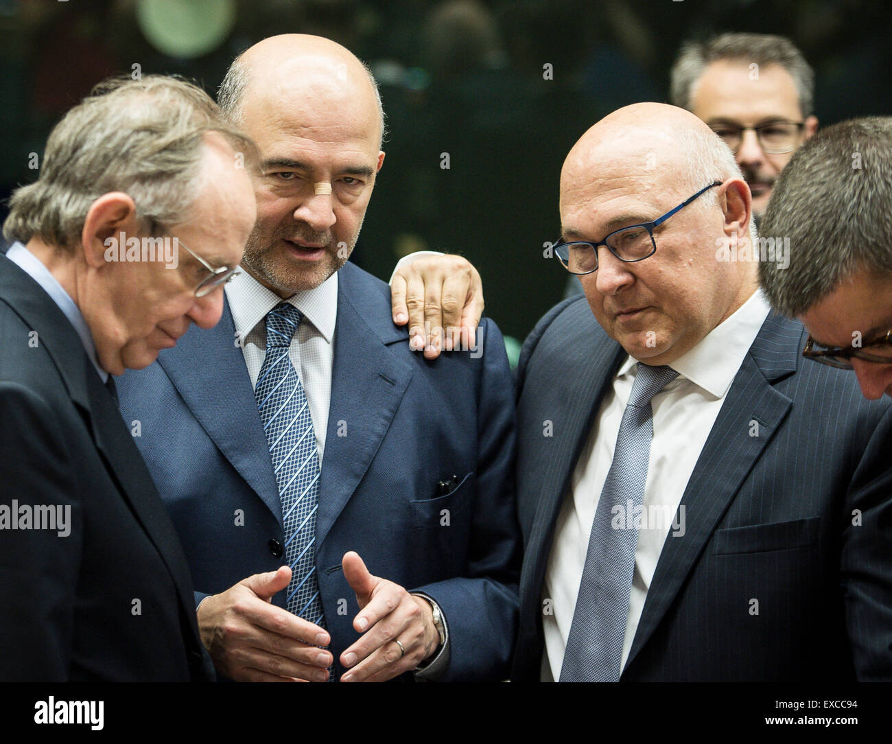 Brussels, Bxl, Belgium. 11th July, 2015. (L-R) Pier Carlo Padoan, Italian Minister for Economy and Finances, Pierre Moscovici, EU commissioner for Economic and financial affairs, taxation and customs union and French Foreign Minister Michel Sapin prior to the Eurogroup, finance ministers of the single currency EURO zone meeting at EU headquarters in Brussels, Belgium on 11.07.2015 Finance Ministers meet to evaluate Greece's request for a new bailout package by Wiktor Dabkowski Credit:  Wiktor Dabkowski/ZUMA Wire/Alamy Live News Stock Photo