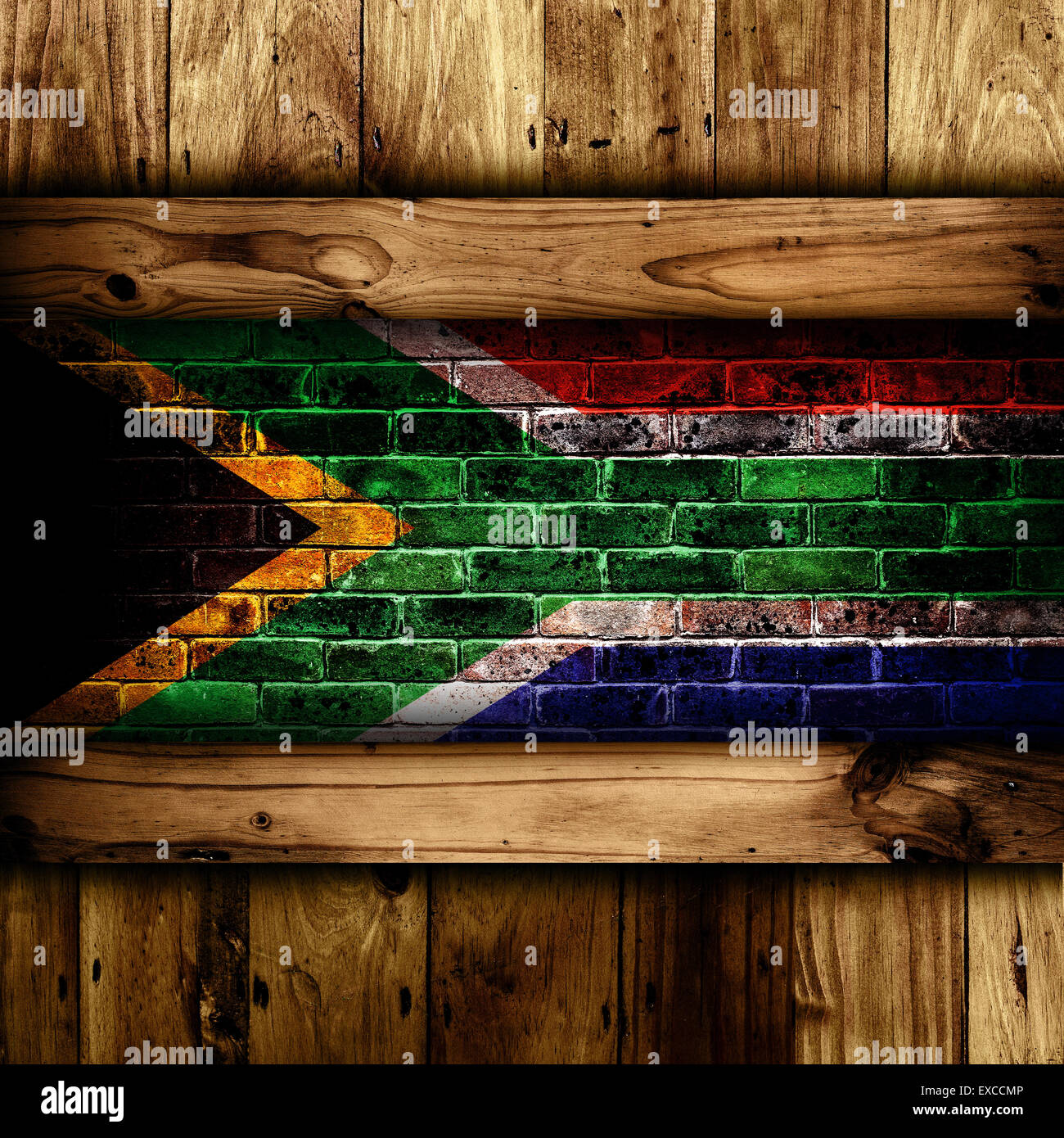 Abstract background of a South African flag on a brick wall framed by wooden panels. Stock Photo