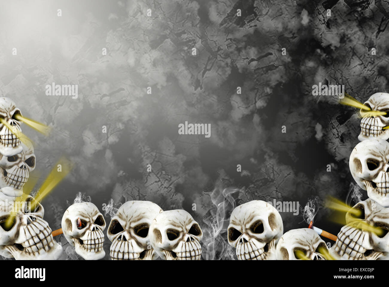 Layers of human skulls with lit cigarettes on textured background. Stock Photo