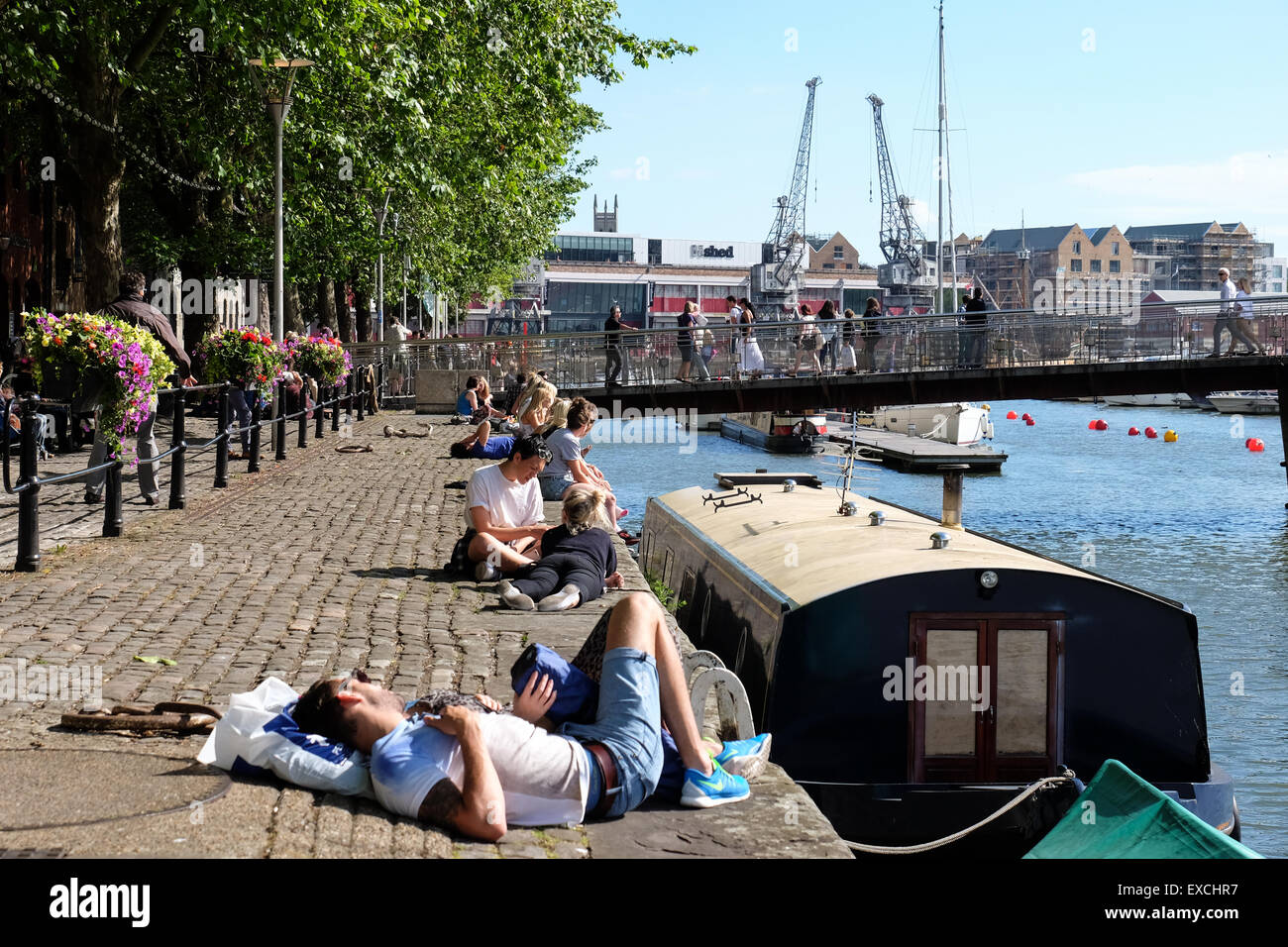 People relaxing and enjoying the sunshine at the Harbourside in Bristol, UK Stock Photo