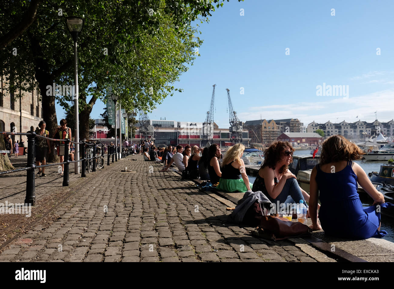 People relaxing and enjoying the sunshine at the Harbourside in Bristol, UK Stock Photo