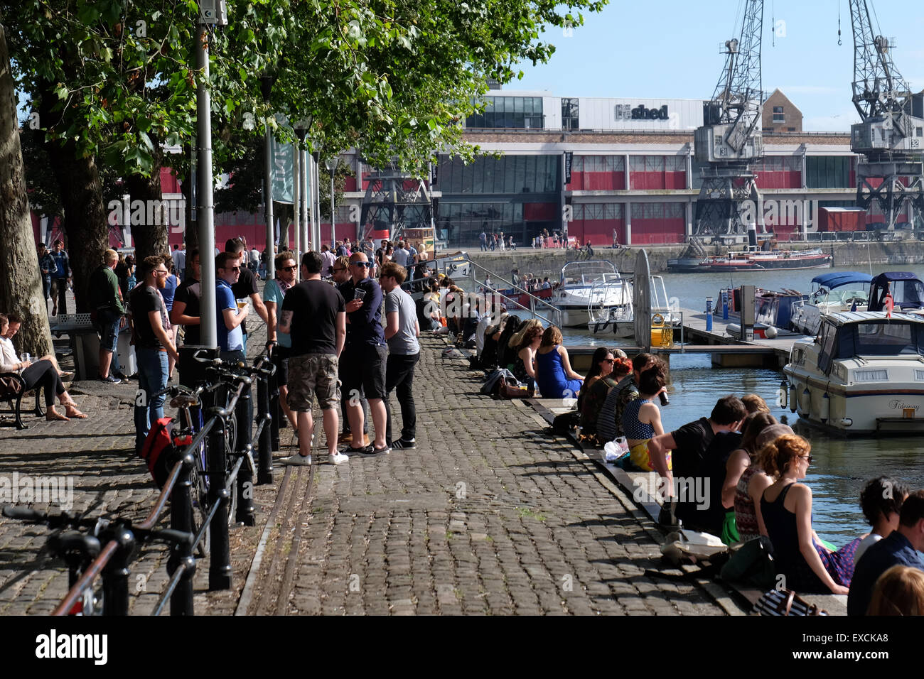 People relaxing and enjoying the sunshine at the Harbourside in Bristol, UK Stock Photo