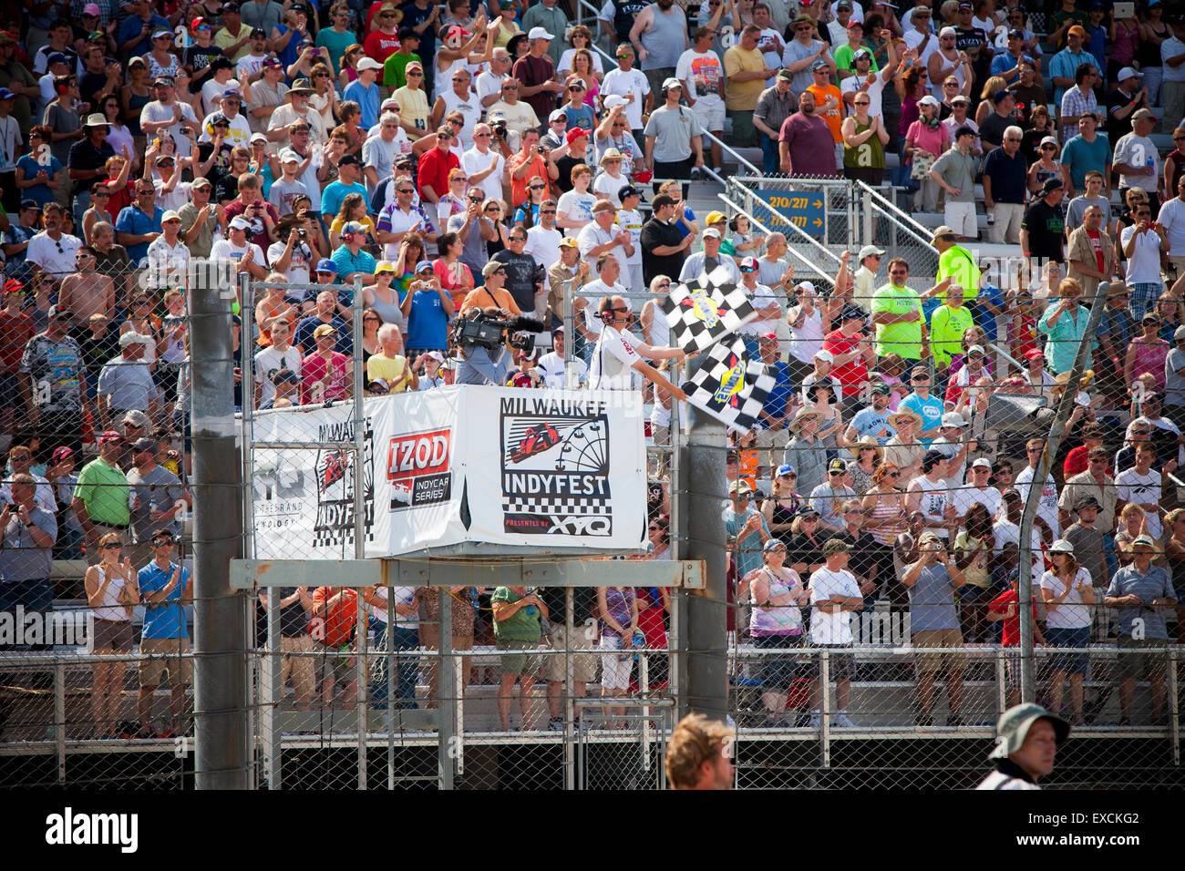 Checker flags wave at the finish line of an IndyCar race Stock Photo