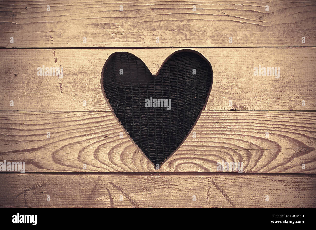 The excised shape of heart in old wooden wall, as decoration. Stock Photo