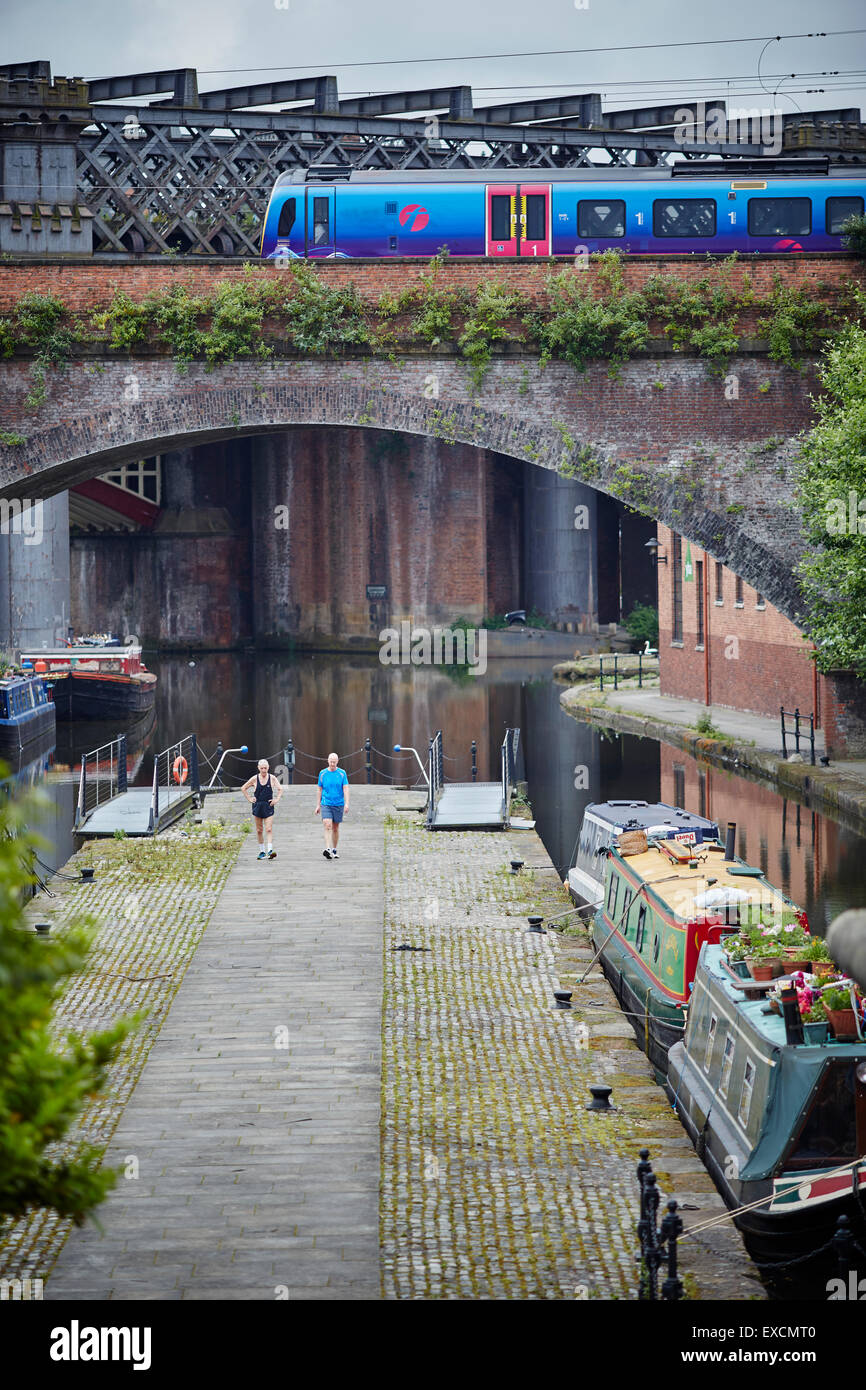 Castlefiled basin in Manchester city centre a First train crosses the viaduct   Boat canal, canals narrowboat  river stream wate Stock Photo