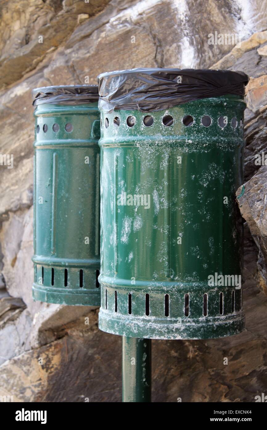 Pair of bins for waste, metal, green color. In the background the rock ...