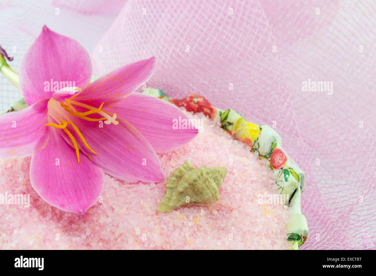 Pink lily flower with pink bath salt in a decoupage decorated  bowl on pink textured background Stock Photo