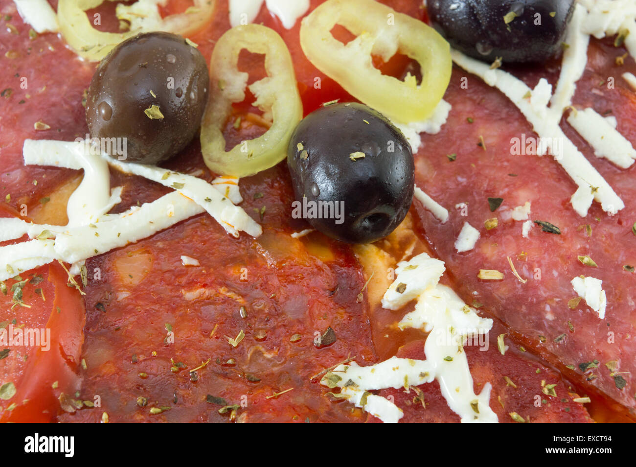 Close up of dark olives and paprika on top of a home baked pizza Stock Photo
