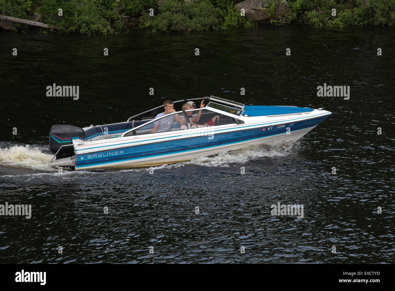 Three teenage boys in a Bayliner speed boat. USA US America Long Lake New York. Adirondack State Park . Stock Photo