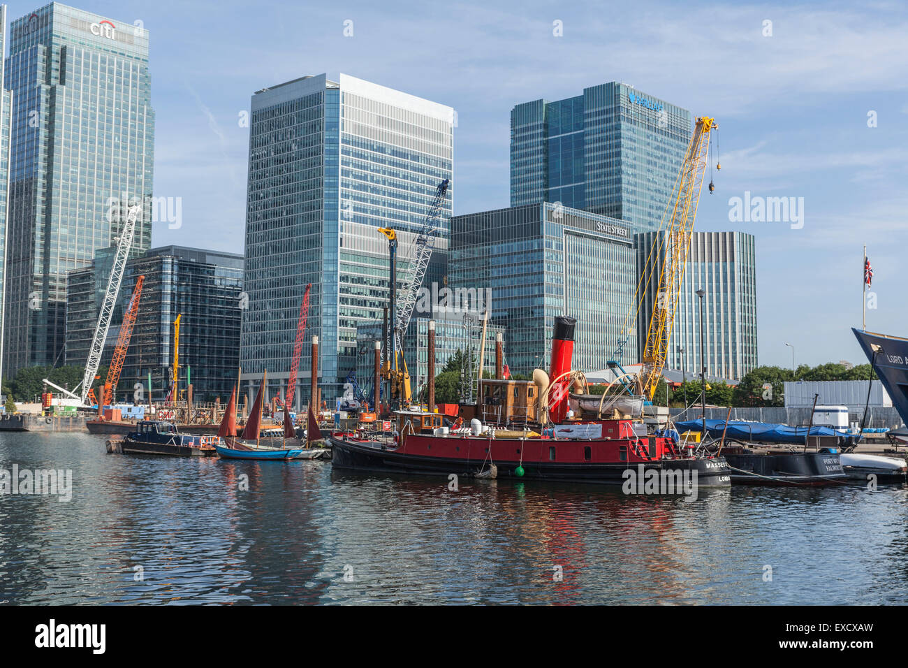 Colourful boats and cranes on the River Thames in front of the modern
