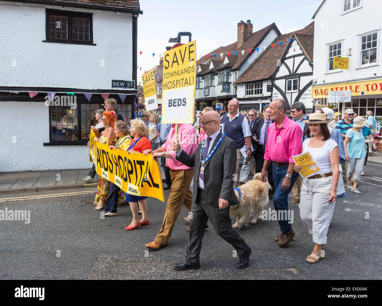 Henley-on-Thames, UK. 11th July, 2015. South Oxfordshire District Councillor Paul Harrison holds aloft a placard as he leads a large crowd of campaigners, including Henley's Mayor Lorraine Hillier, in a peaceful protest march in Henley-on-Thames, Oxfordshire, England, on Saturday 11 July 2015 against the Oxfordshire Clinical Commissioning Group's plans for its new health campus, Townlands Hospital.  The new hospital was originally planned to have 18 beds, now changed to 5 beds in a care home to be built next to the hospital Credit:  Graham Prentice/Alamy Live News Stock Photo