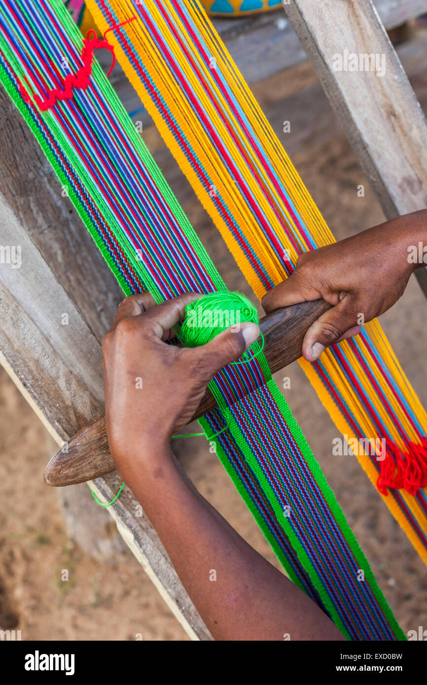 Wayuu indigenous woman weaving the strap of a 'mochila', or traditional handbag, in a Wayuu Rancheria, or rural settlement, in L Stock Photo