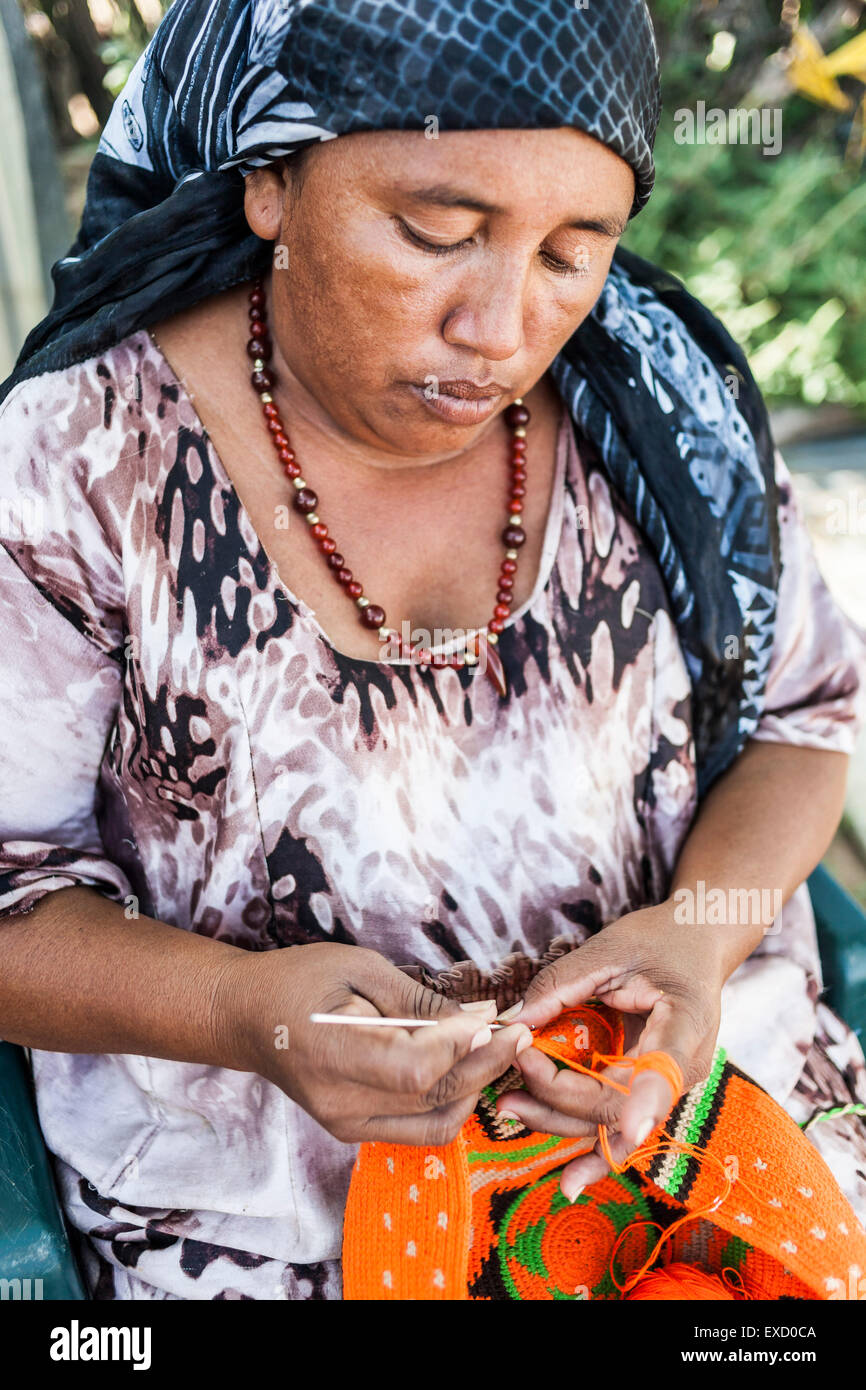 Middle-aged Wayuu indigenous woman knitting a 'mochila' or shoulder bag.  Knitting, crocheting and weaving are fundamental to th Stock Photo