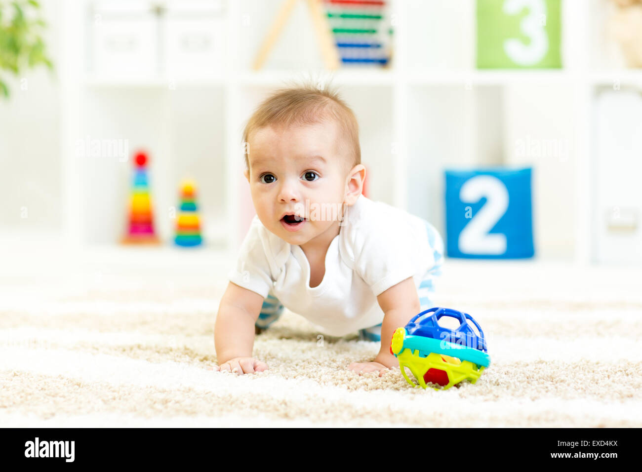 crawling funny baby boy indoors at nursery Stock Photo