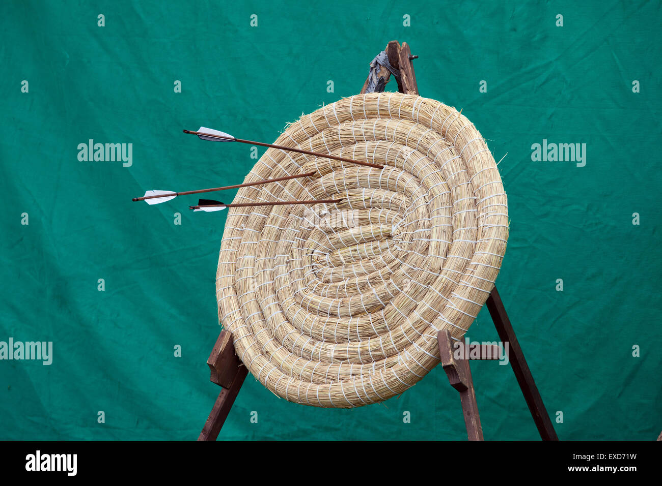 Traditional archery round coiled straw target on a stand with three ...