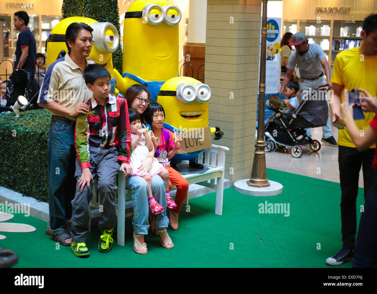 Family posing for photo with Bob, Stuart and Kevin, characters of the ...