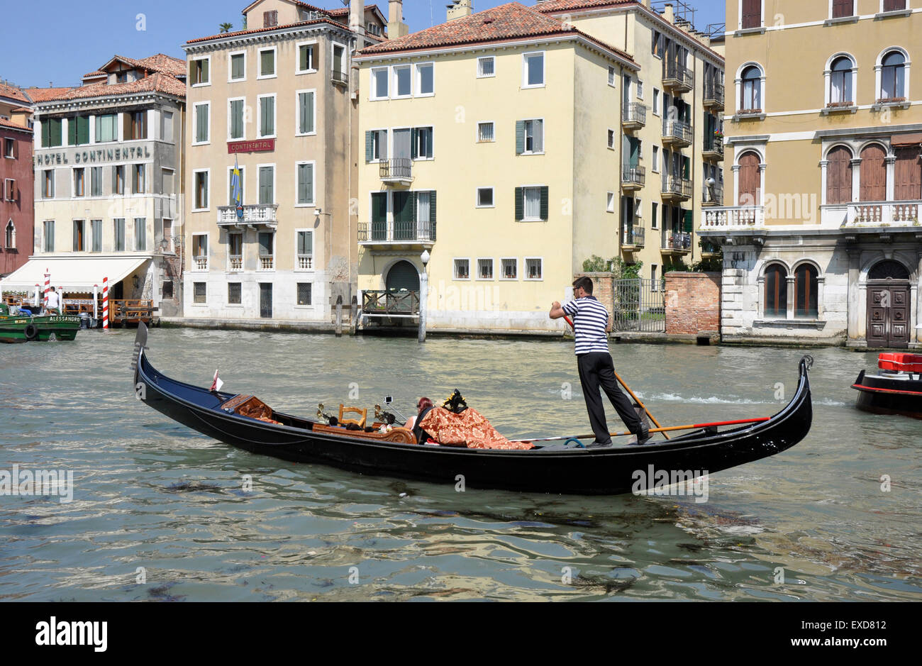 Italy Venice Cannaregio area - on Canale Grande- traditional gondola - gondolier - tourist couple taking selfies - sunlight Stock Photo