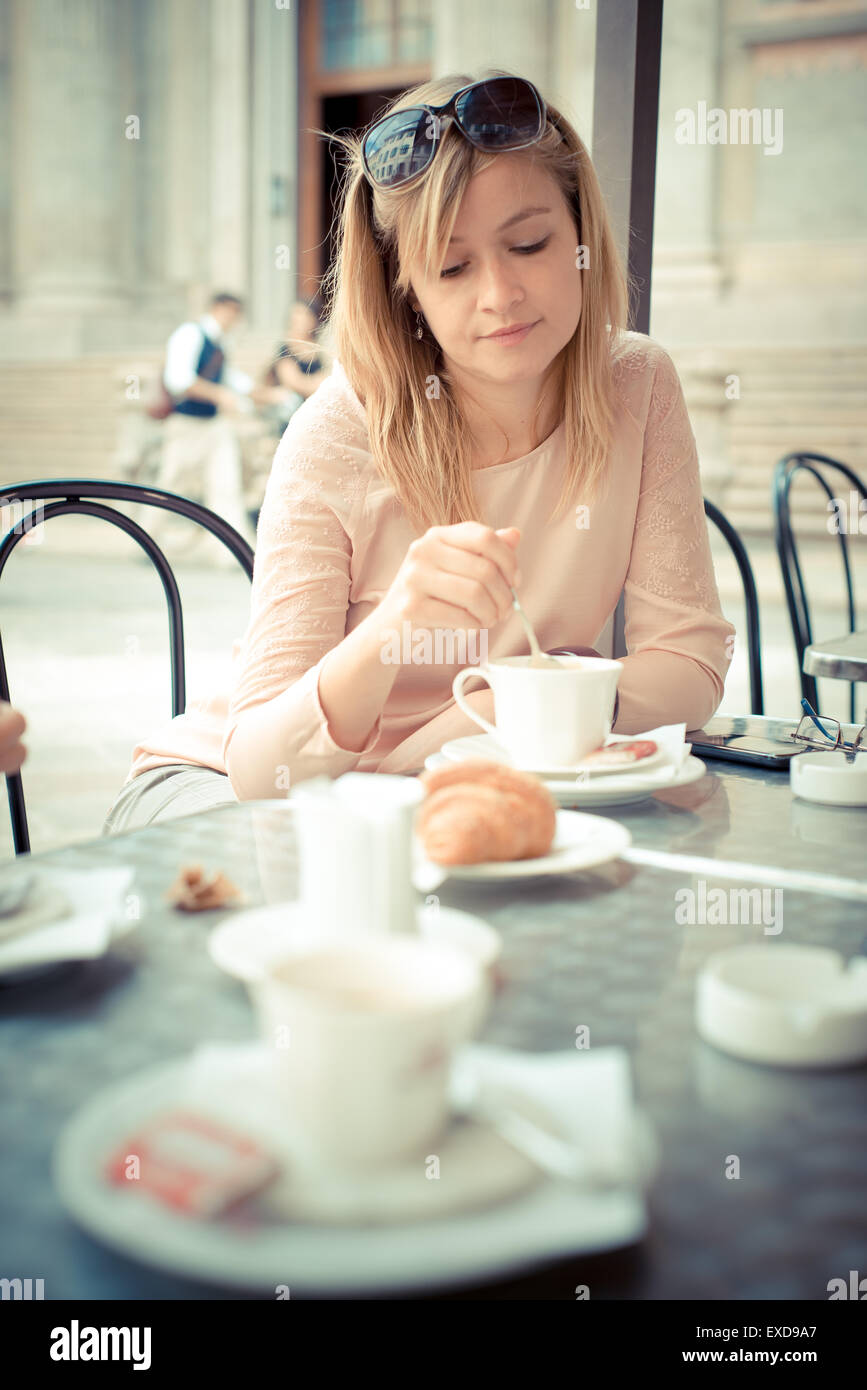 beautiful blonde woman having breakfast at the bar in the city Stock Photo