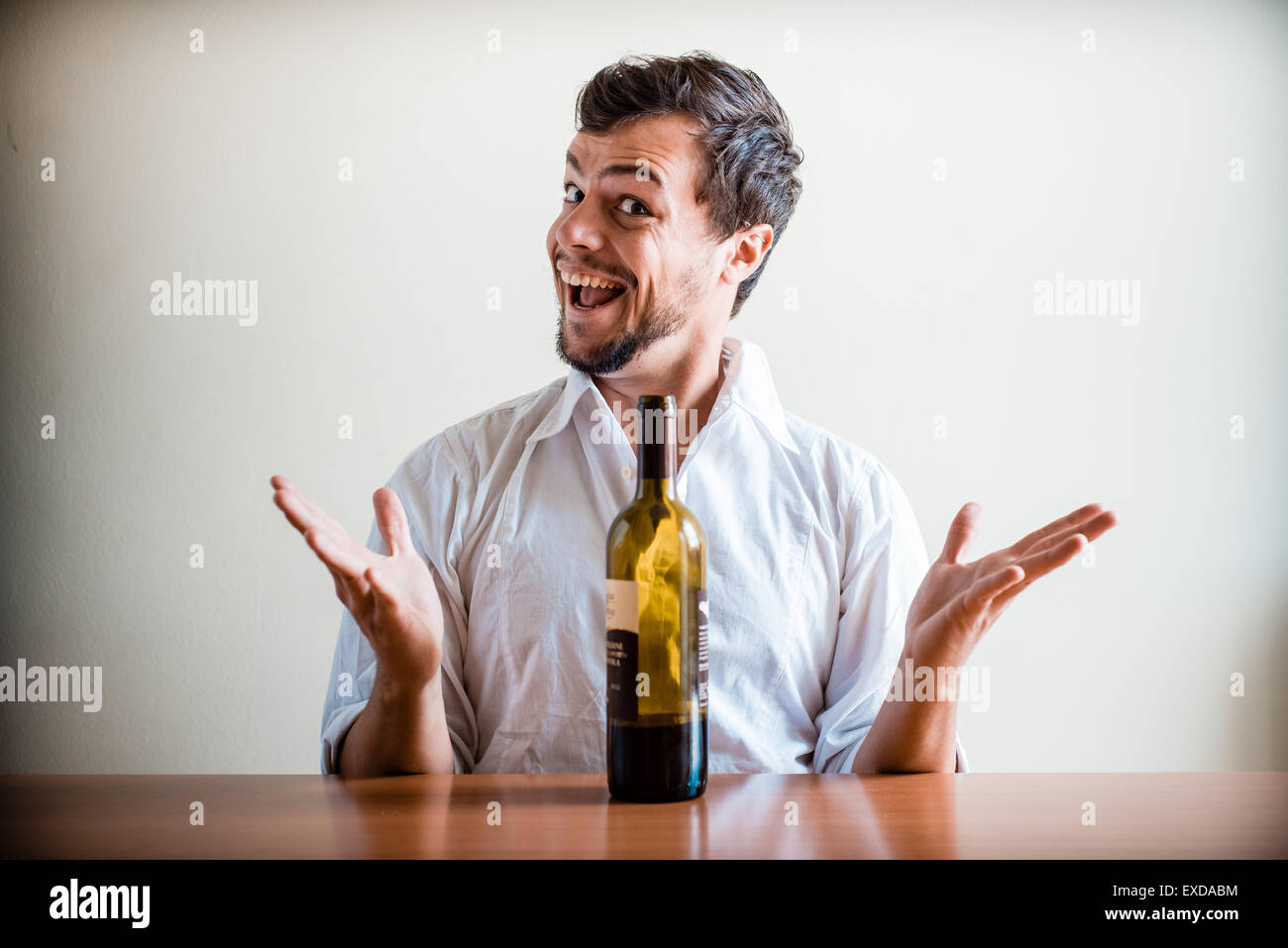 drunk young stylish man with white shirt behind a table Stock Photo - Alamy