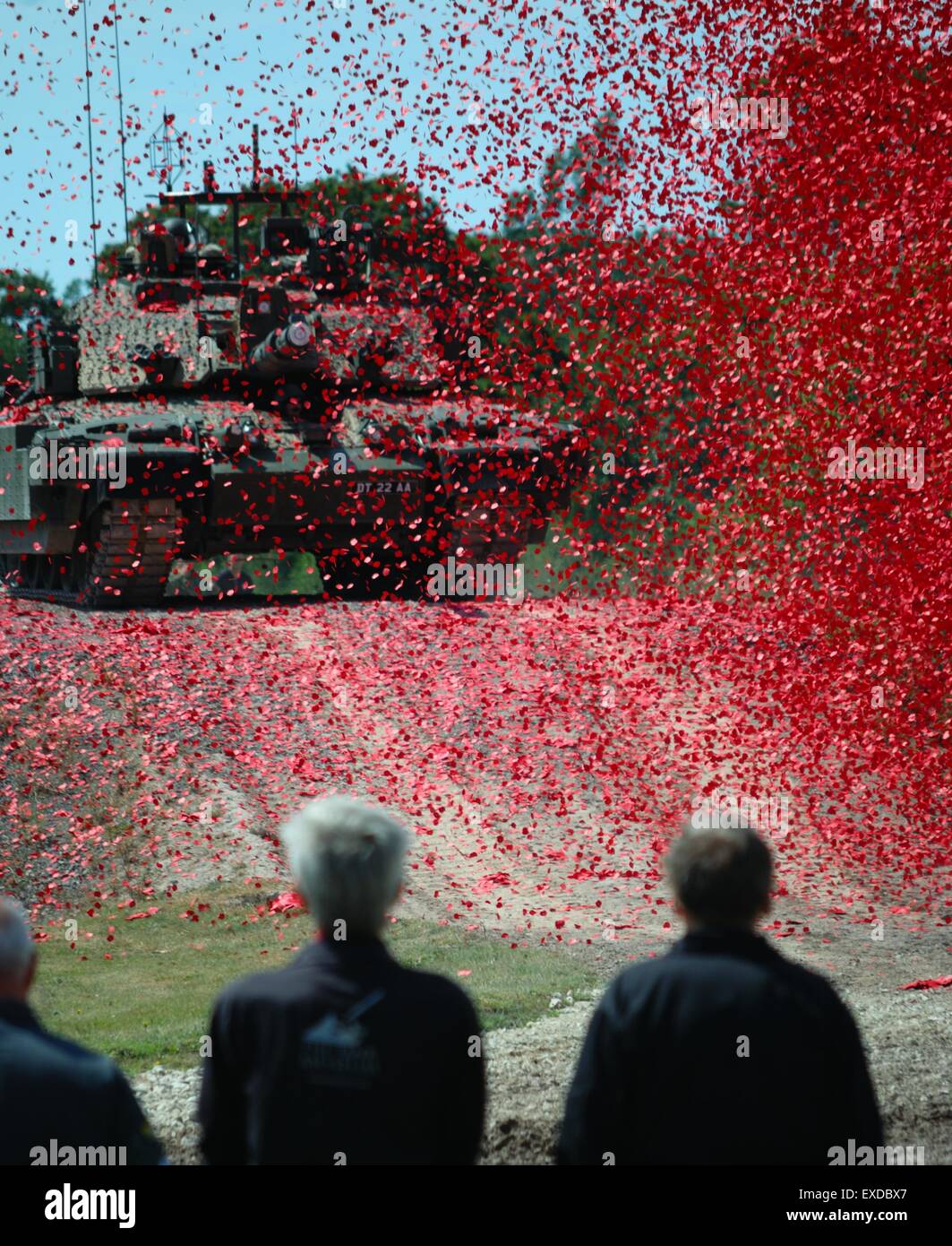 Poppies shroud a tank during First World War centenary event at Bovington Tank Museum, Dorset, UK, 2014 while people look on during a ceremony Stock Photo