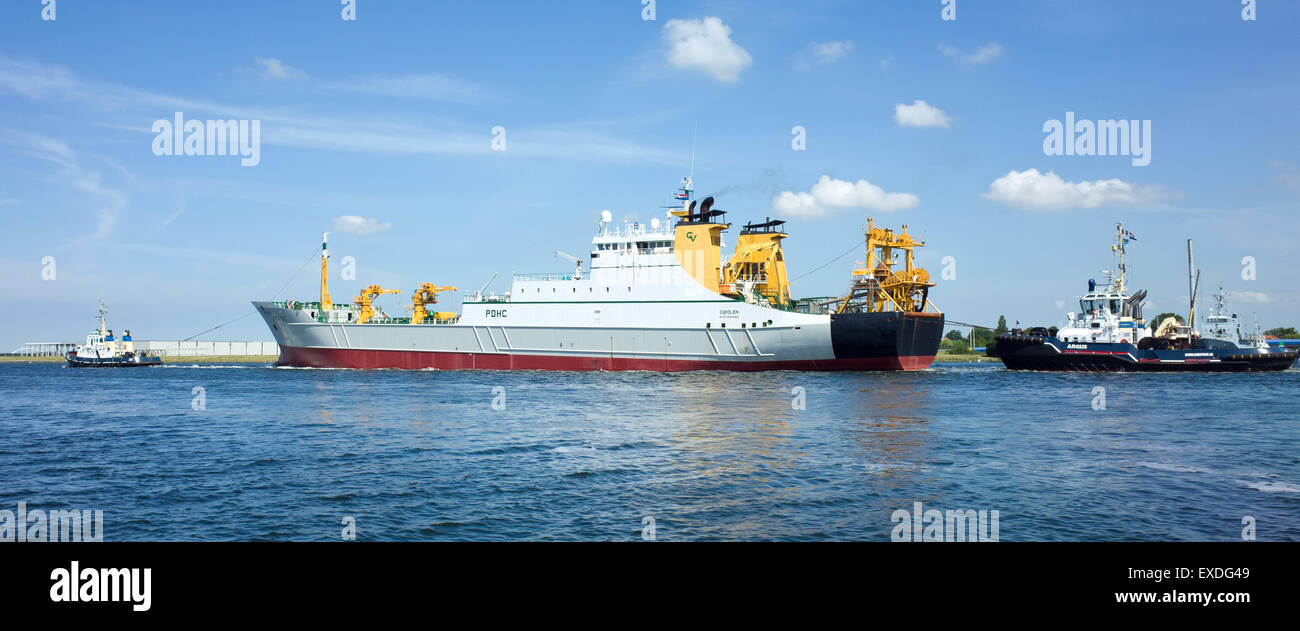 Tugs towing and pushing large Ship or boat Ijmuiden Holland Stock Photo