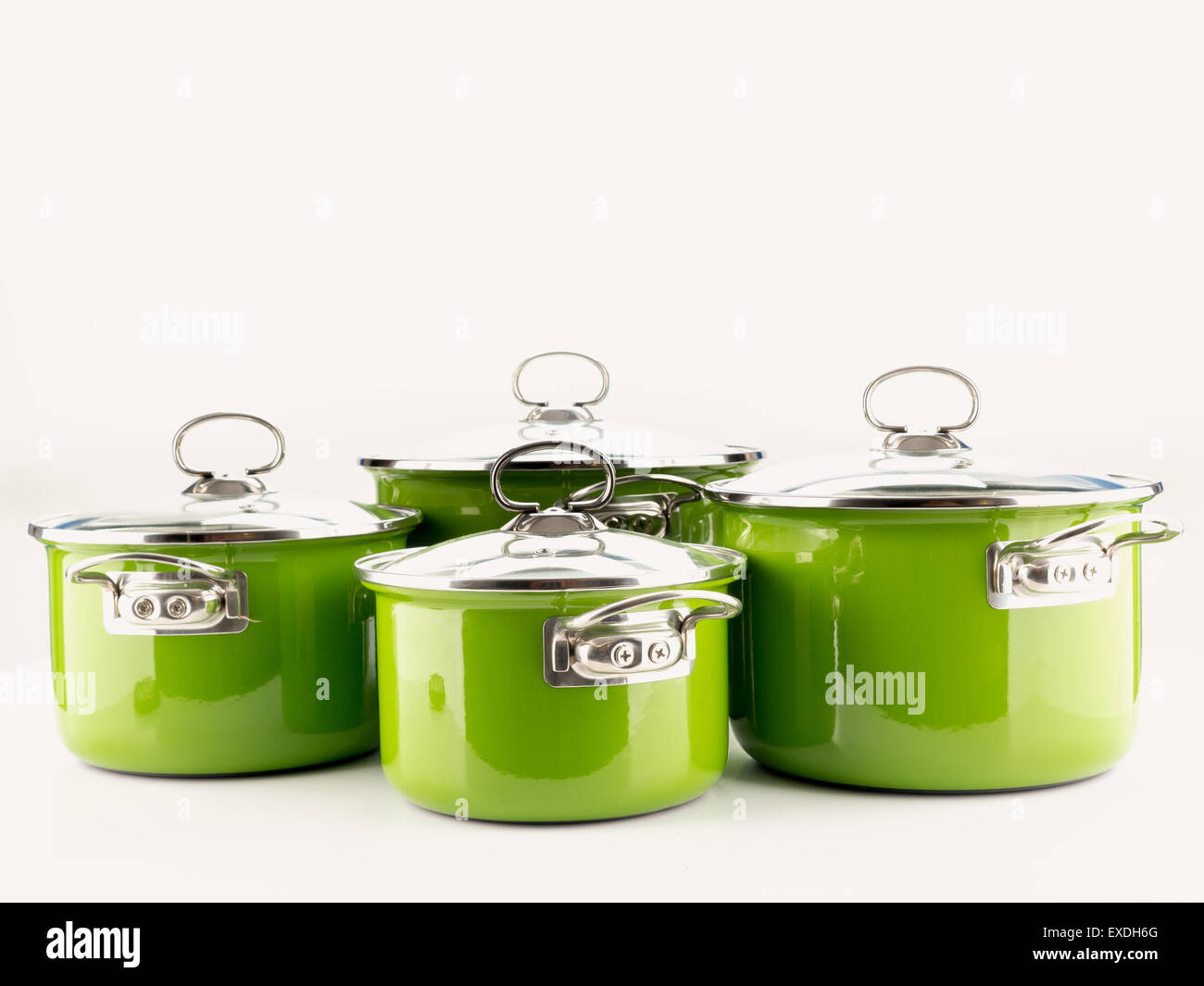 Set of four green enamel pots with lids shot on white Stock Photo