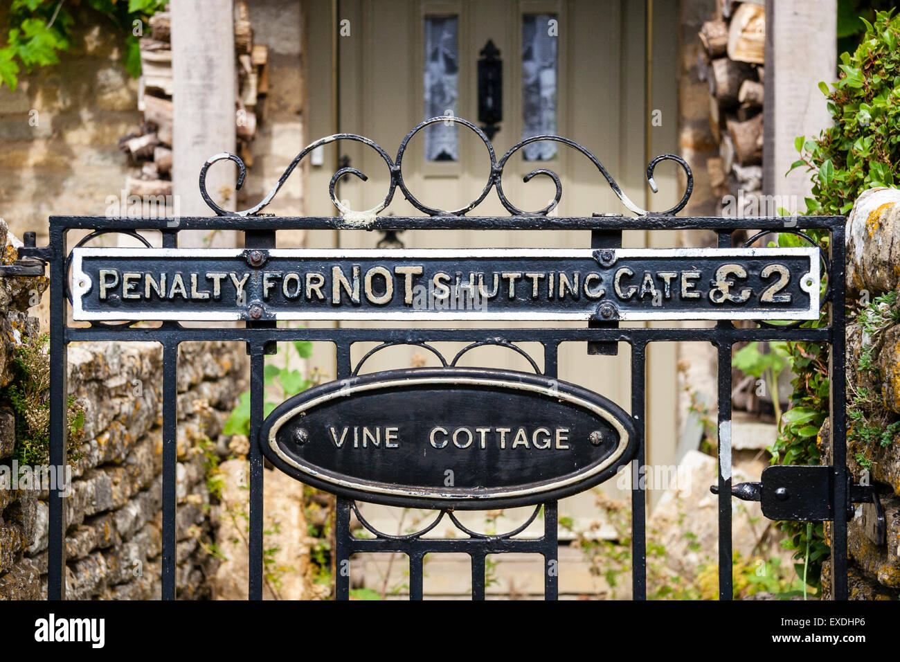 Rural English stone house 'Vine Cottage' in Cotswold village, Lower Slaughter, close up of gate and sign, Penalty for not shutting the gate £2 Stock Photo