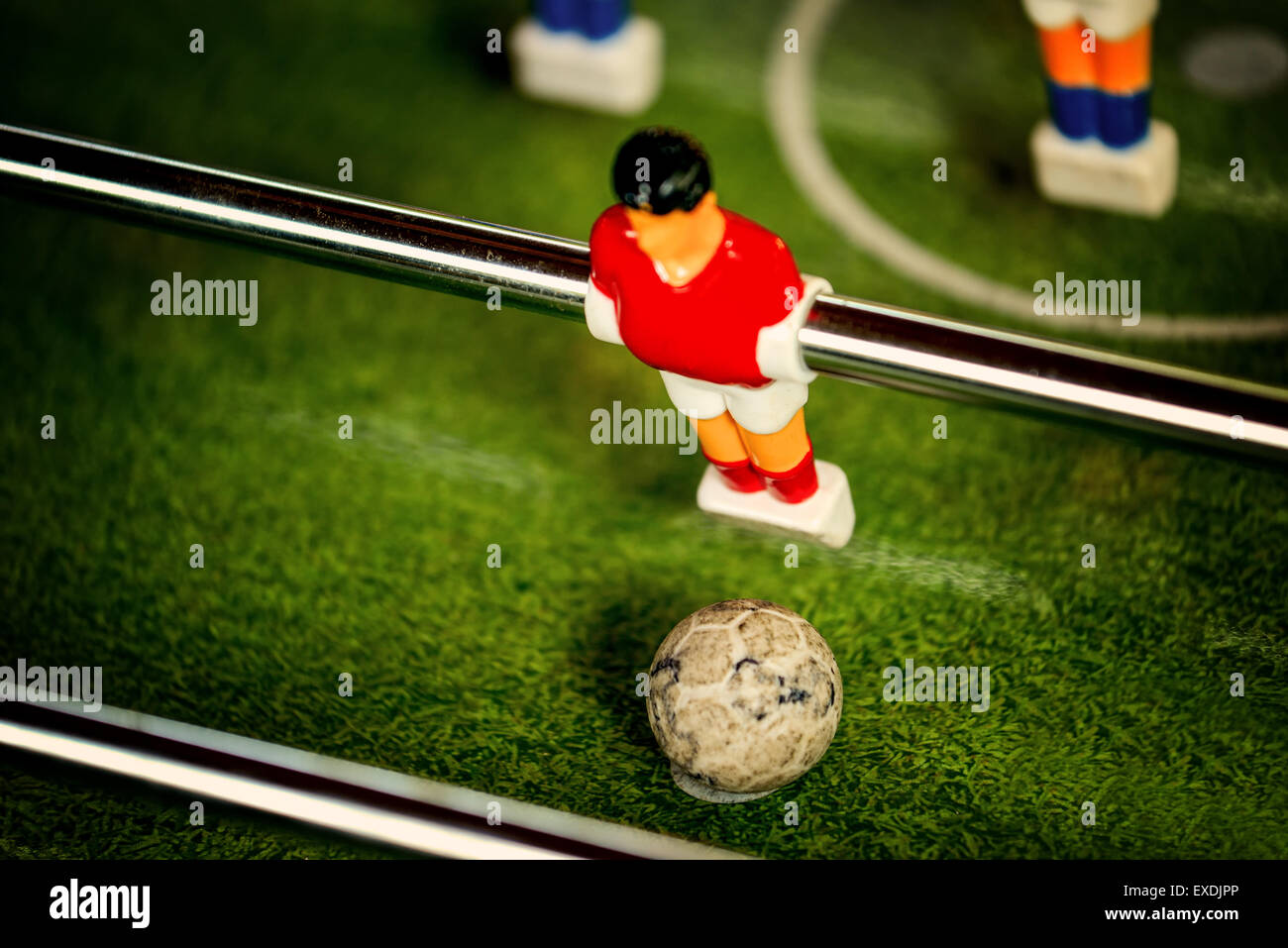 Vintage Table Soccer Player Figure in Red Jersey Kicking the Ball, Selective Focus, Retro Tone Effect Stock Photo