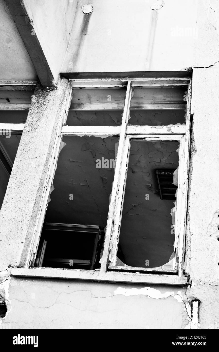 A broken window in a derelict building Stock Photo