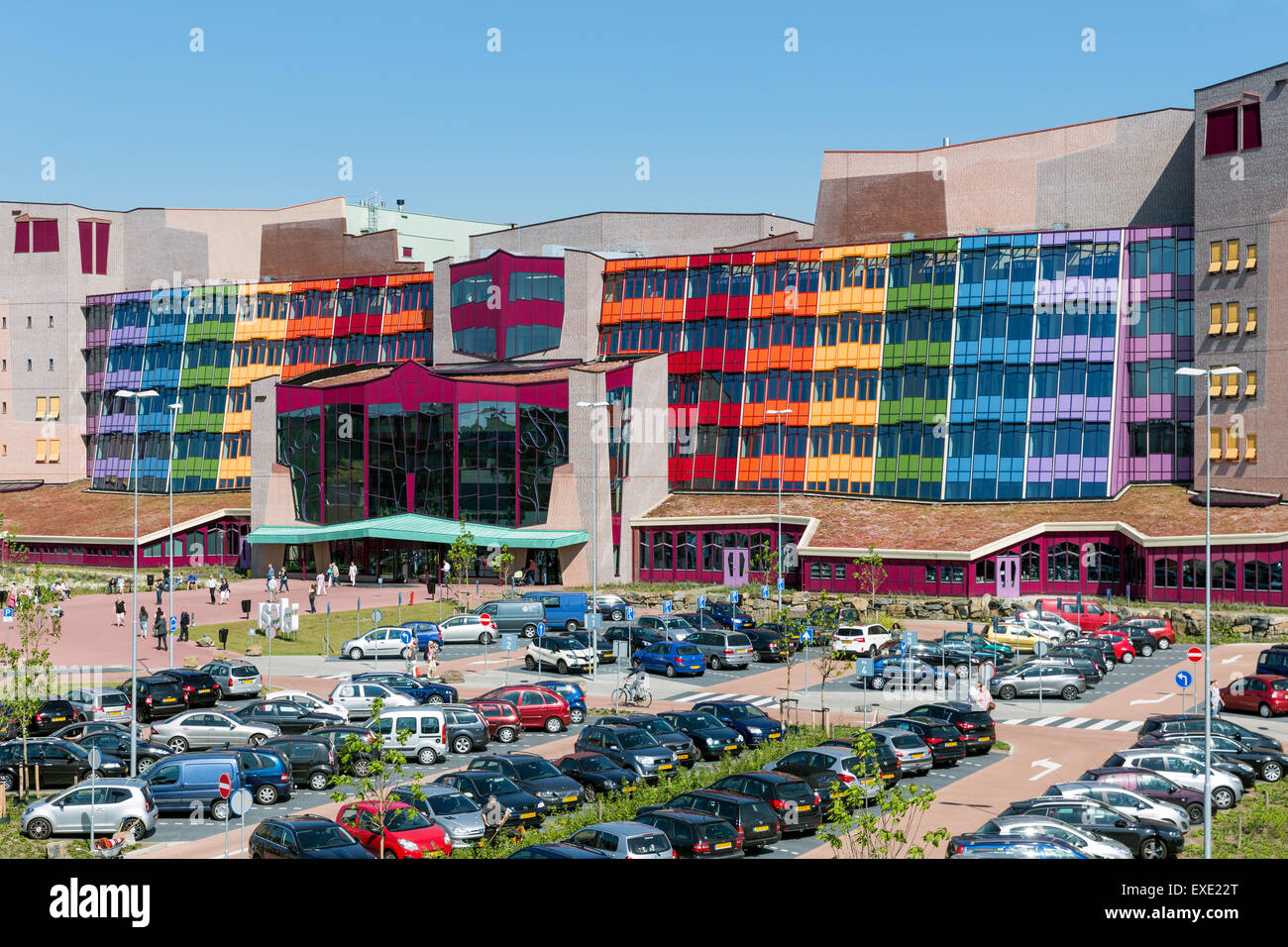 People visiting the new modern Isala Hospital with a big car park in front of it in Zwolle, the Netherlands Stock Photo
