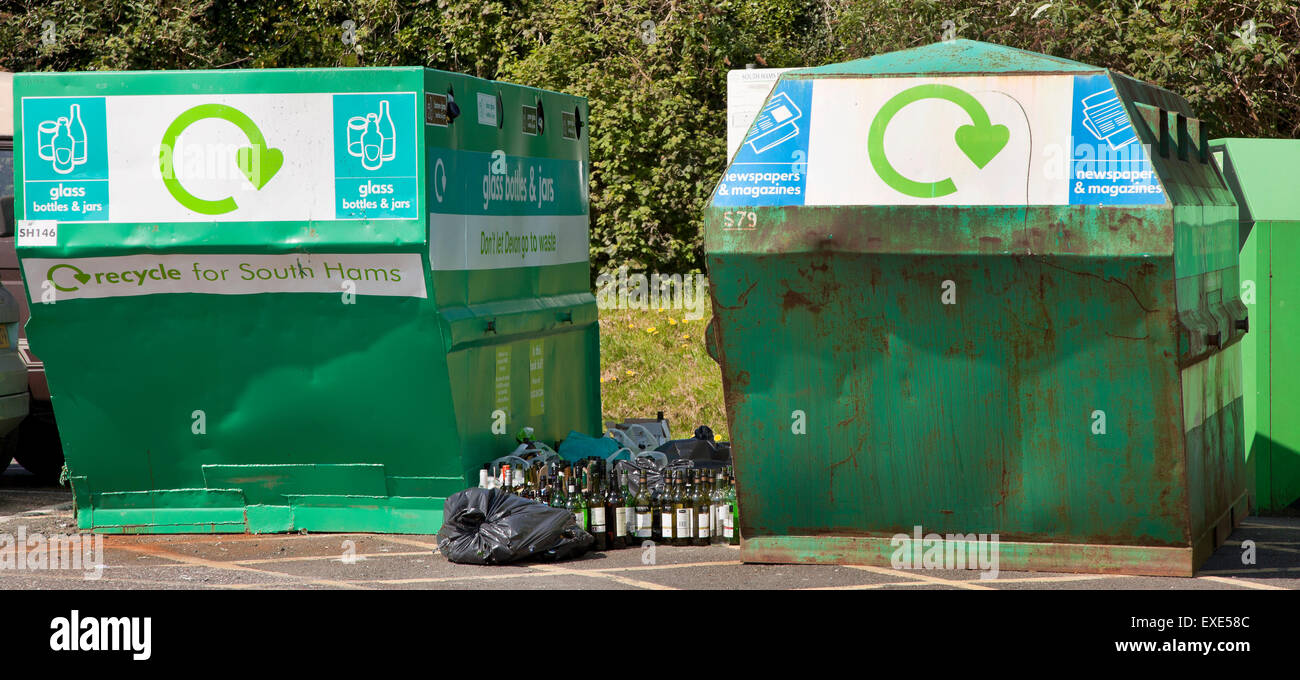 Glass recycling skips with bottles awaiting disposal, bright sun Stock Photo