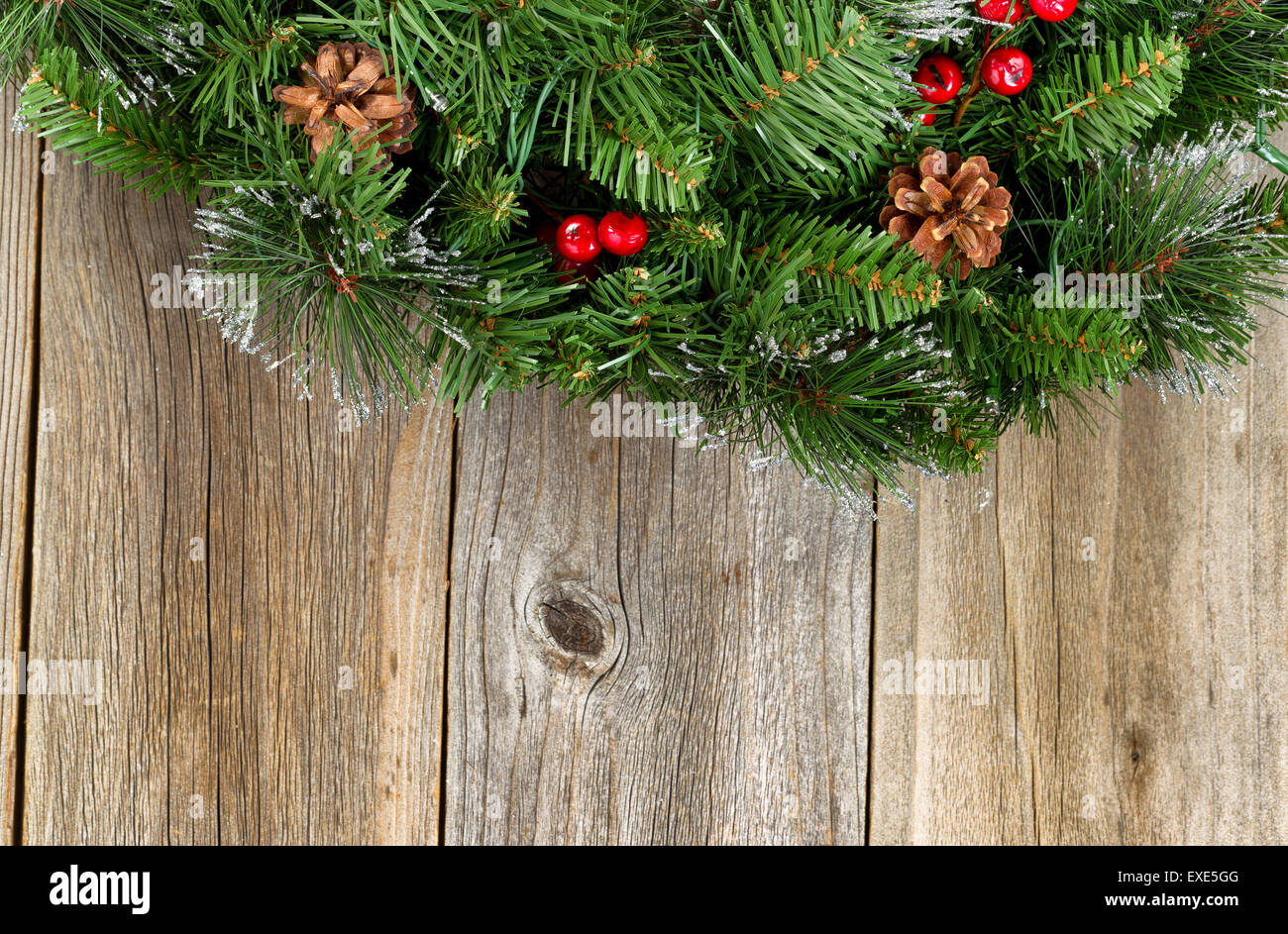 Christmas border with decorative wreath on rustic wooden boards. Stock Photo