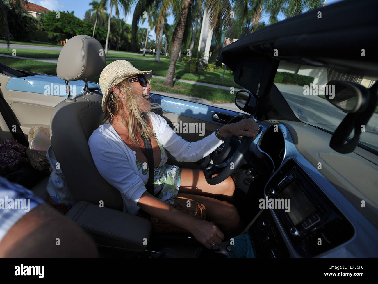 Woman enjoys singing in a convertable car in sun lifestyle Stock Photo