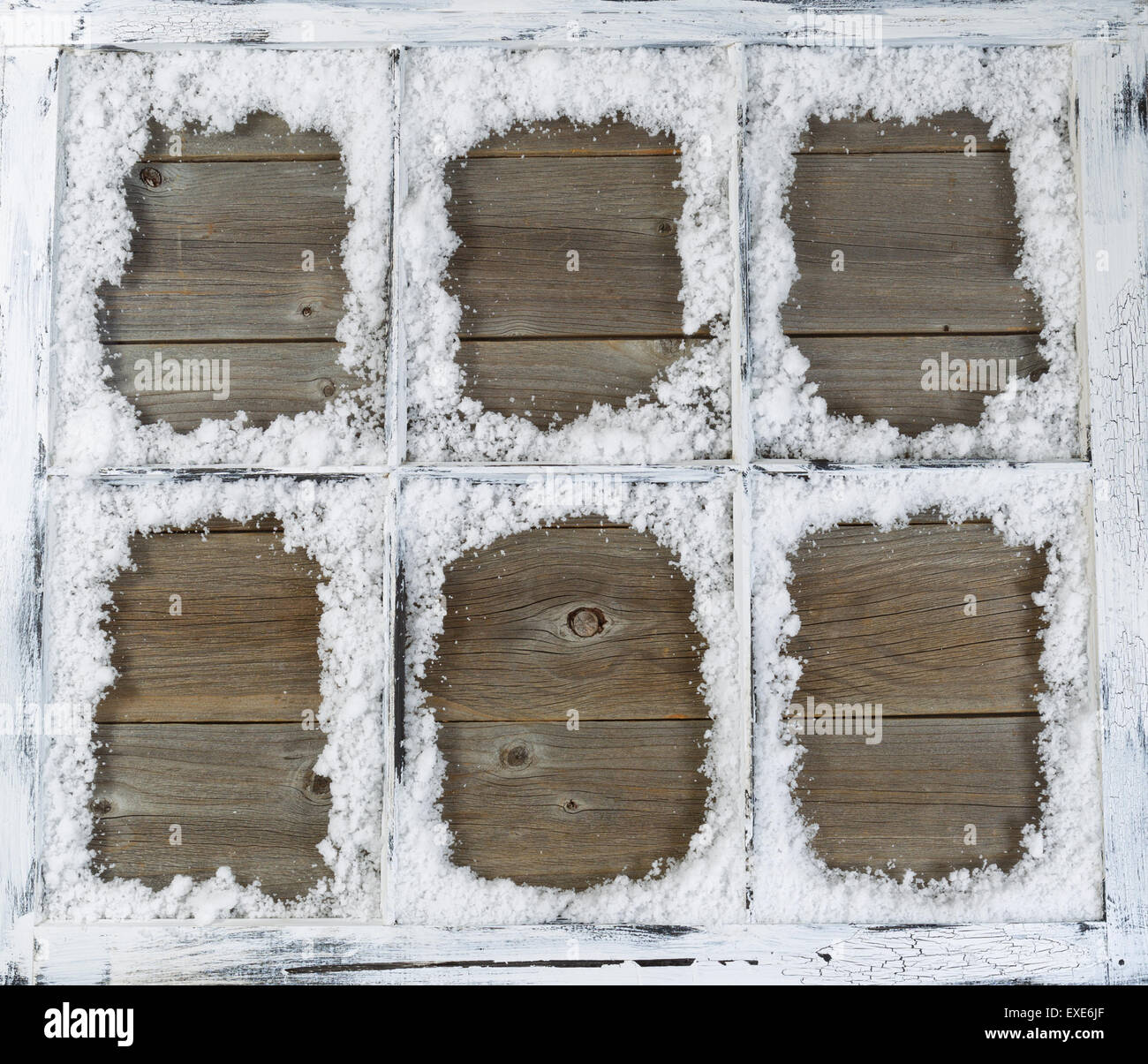 Vintage six pane window, with powdered snow, on rustic wood. Stock Photo