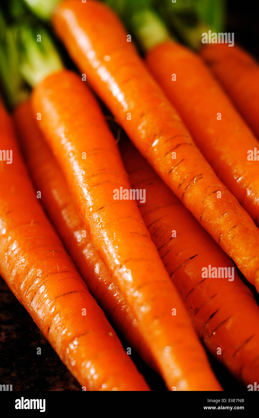 A bunch of fresh carrots on a granite counter top. Stock Photo