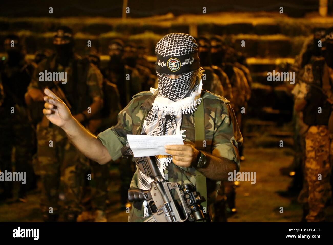 Gaza, Palestine. 12th July, 2015. Militants from al-Nasser Salah al-Deen Brigade, the military wing of the Popular Resistance Committees march during an anti-Israel rally marking the first anniversary of the 50-day Israeli war on Gaza Strip last summer. © Nidal Alwaheidi/Pacific Press/Alamy Live News Stock Photo