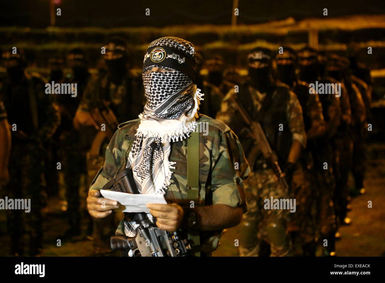 Gaza, Palestine. 12th July, 2015. Militants from al-Nasser Salah al-Deen Brigade, the military wing of the Popular Resistance Committees march during an anti-Israel rally marking the first anniversary of the 50-day Israeli war on Gaza Strip last summer. © Nidal Alwaheidi/Pacific Press/Alamy Live News Stock Photo