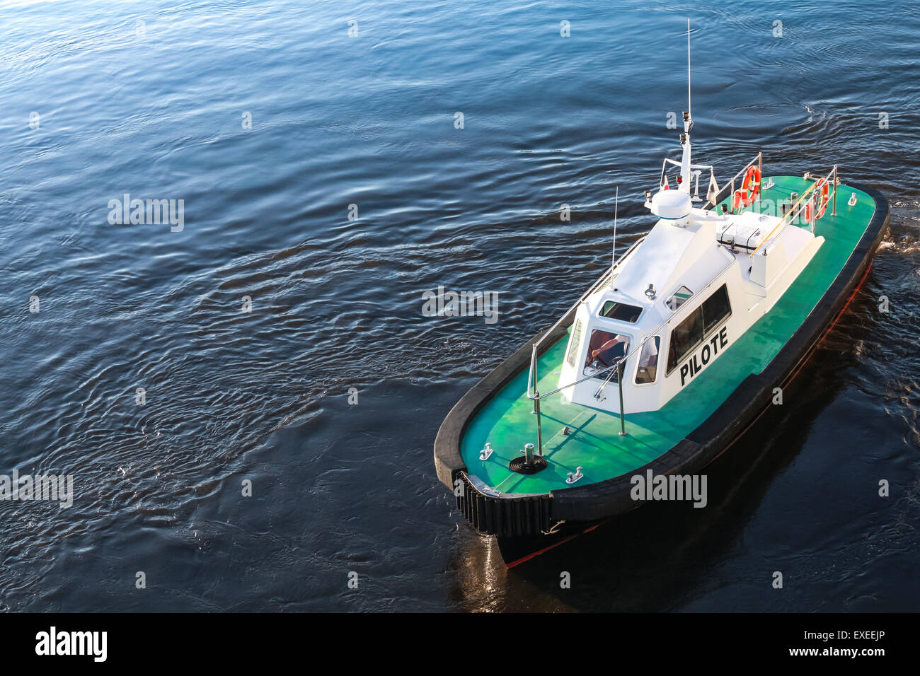 Small pilot boat with green deck on a sea water Stock Photo