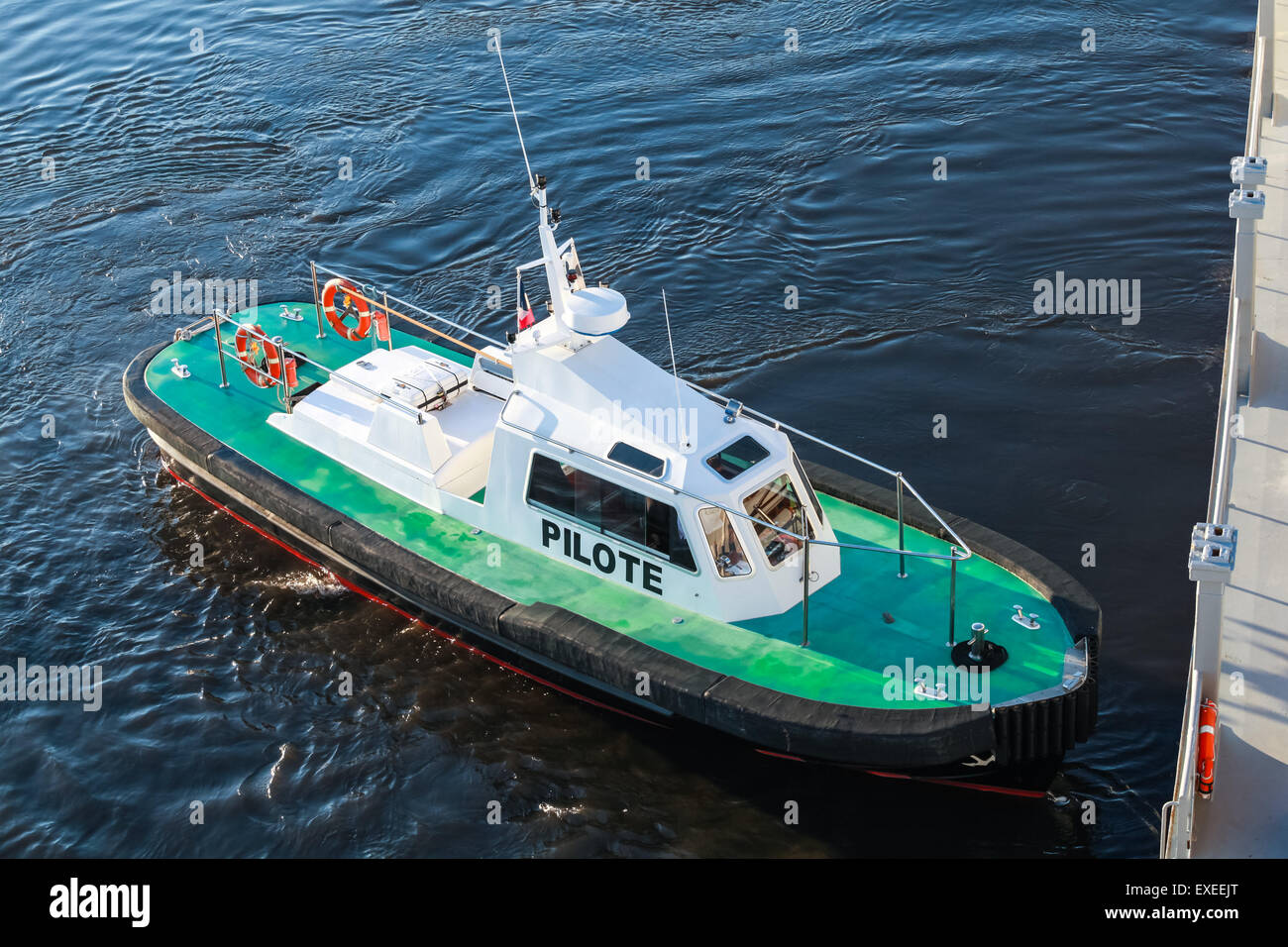 Small pilot boat with green deck and black hull on a sea water Stock Photo