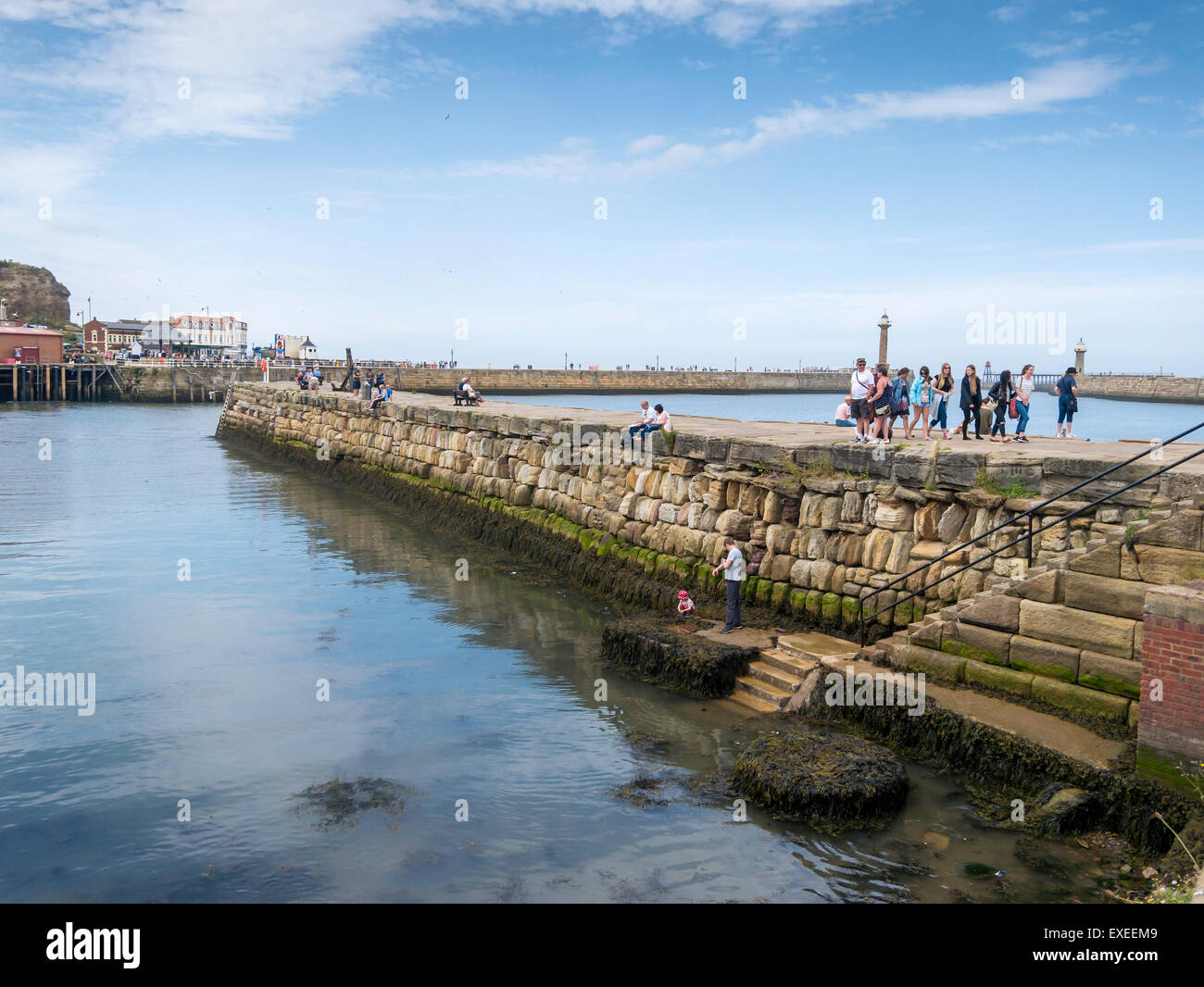 Holiday makers on Tate Hill Pier Whitby North Yorkshire, the pier buiLt in A.D.1190 is one of the oldest in the world Stock Photo