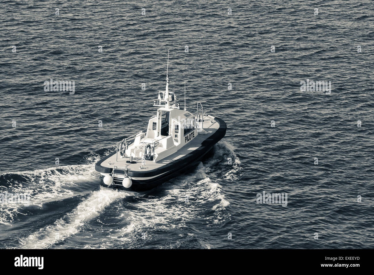 Small pilot boat is underway on a sea water, monochrome photo Stock Photo