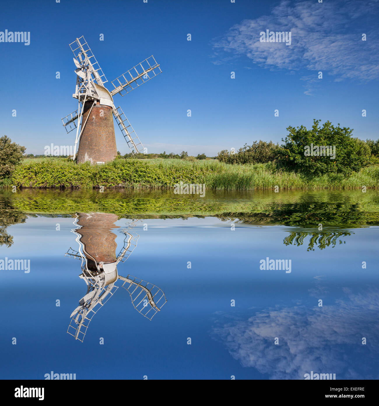 Turf Fen Winmill reflecting in the smooth waters of the Norfolk Broads, Norfolk, England Stock Photo